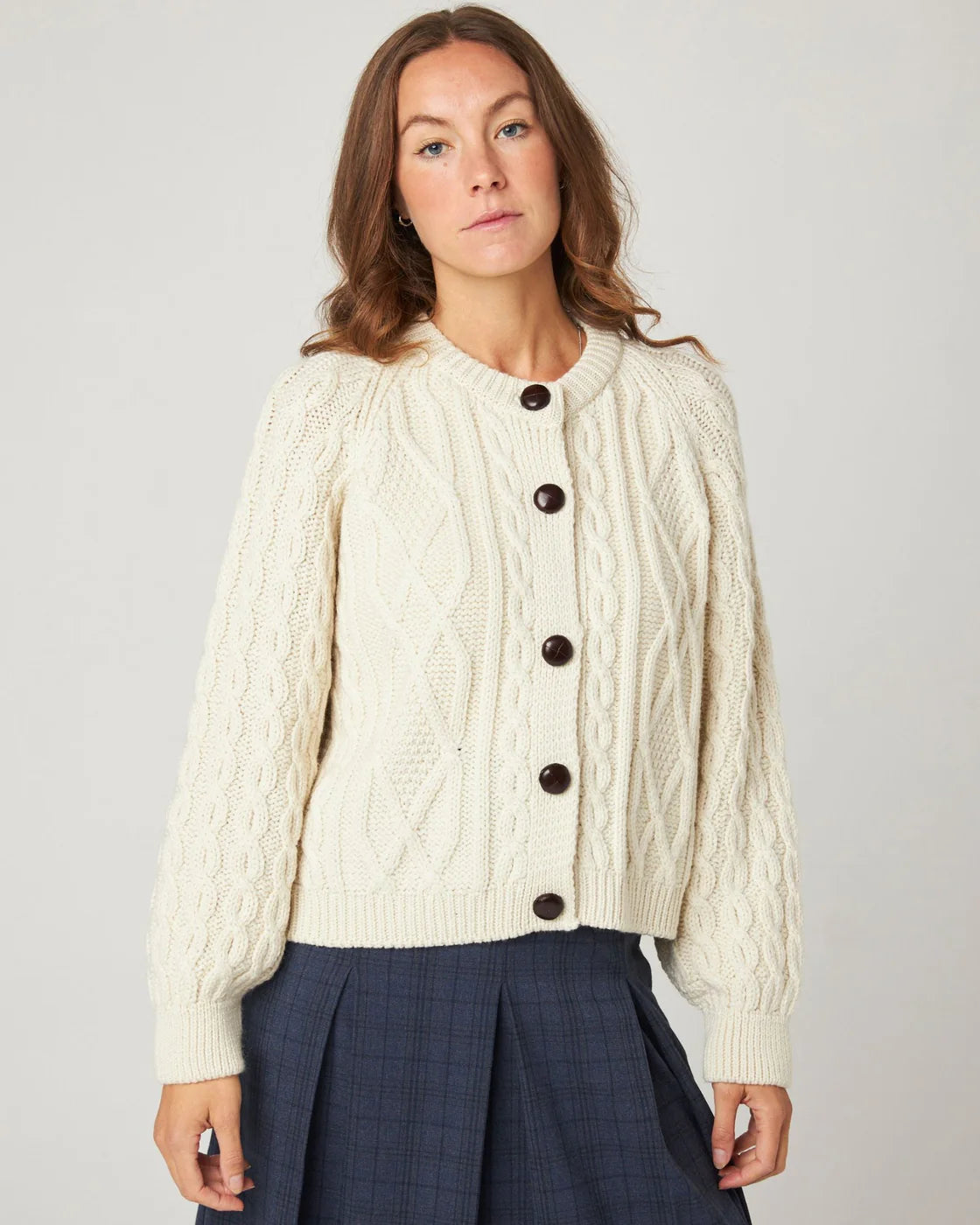 Model wearing cream ecru cable knitted merino wool cardigan by Peregrine Clothing, filtered for the Light Spring, Clear Spring, and Warm Spring colour seasons.