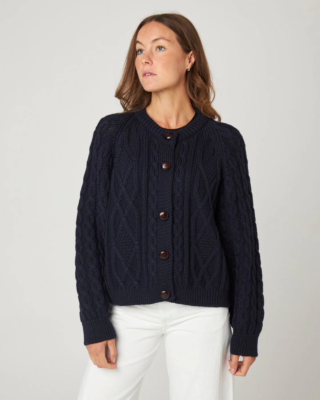 Model wearing a navy cable knit merino wool cardigan by Peregrine Clothing, filtered for the Deep Winter and Cool Winter colour seasons.
