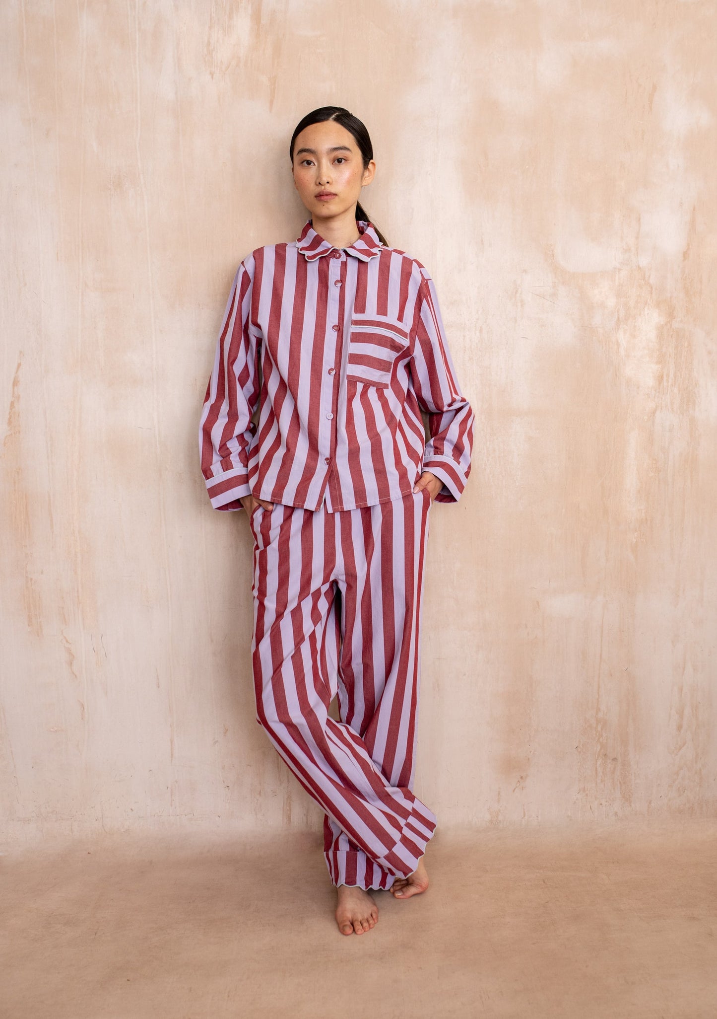 Burgundy and lilac striped cotton pyjama set with button-up long sleeve top and matching trousers.