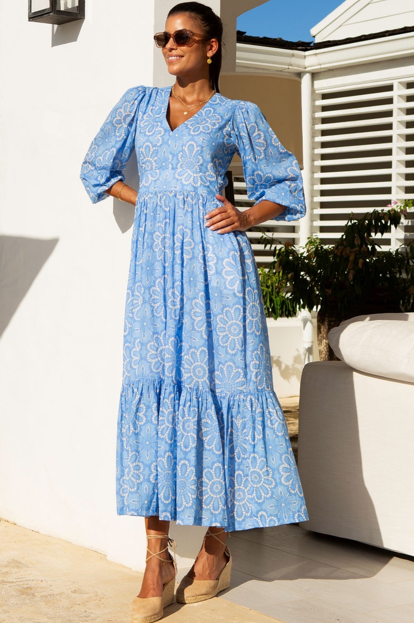 Light blue floral maxi dress with V-neckline, long sleeves, fitted waist, and tiered skirt.
