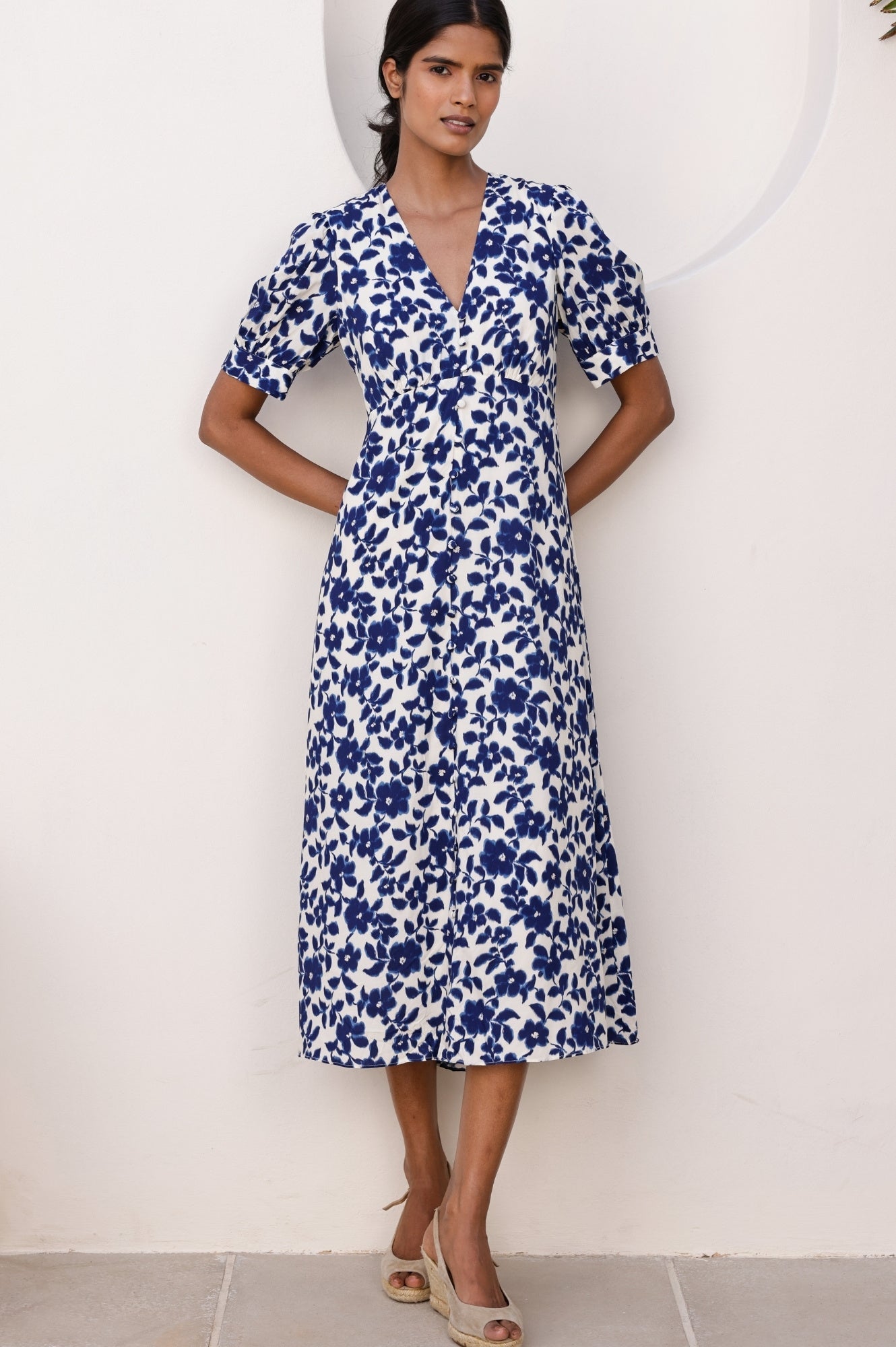 White and navy floral midi dress with V-neckline, short sleeves, fitted waist, and button-through front.