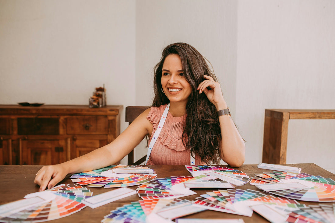 Colour analyst seated at a table covered in colour swatches. Photo by Helena Lopes on Unsplash.