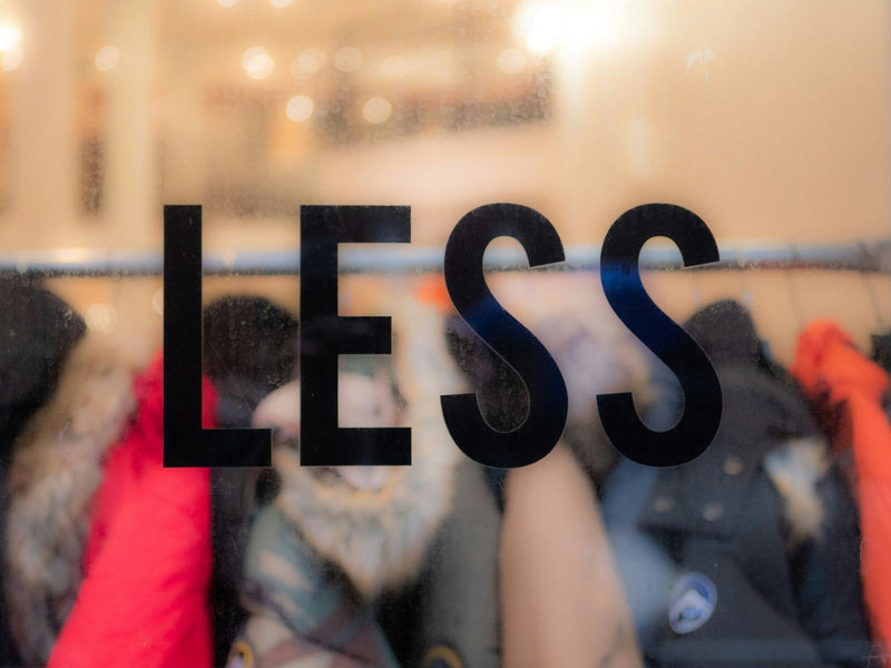 Shop window with LESS written on the glass.