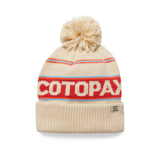 Warm cream bobble hat with Cotopaxi logo on a red stripe.