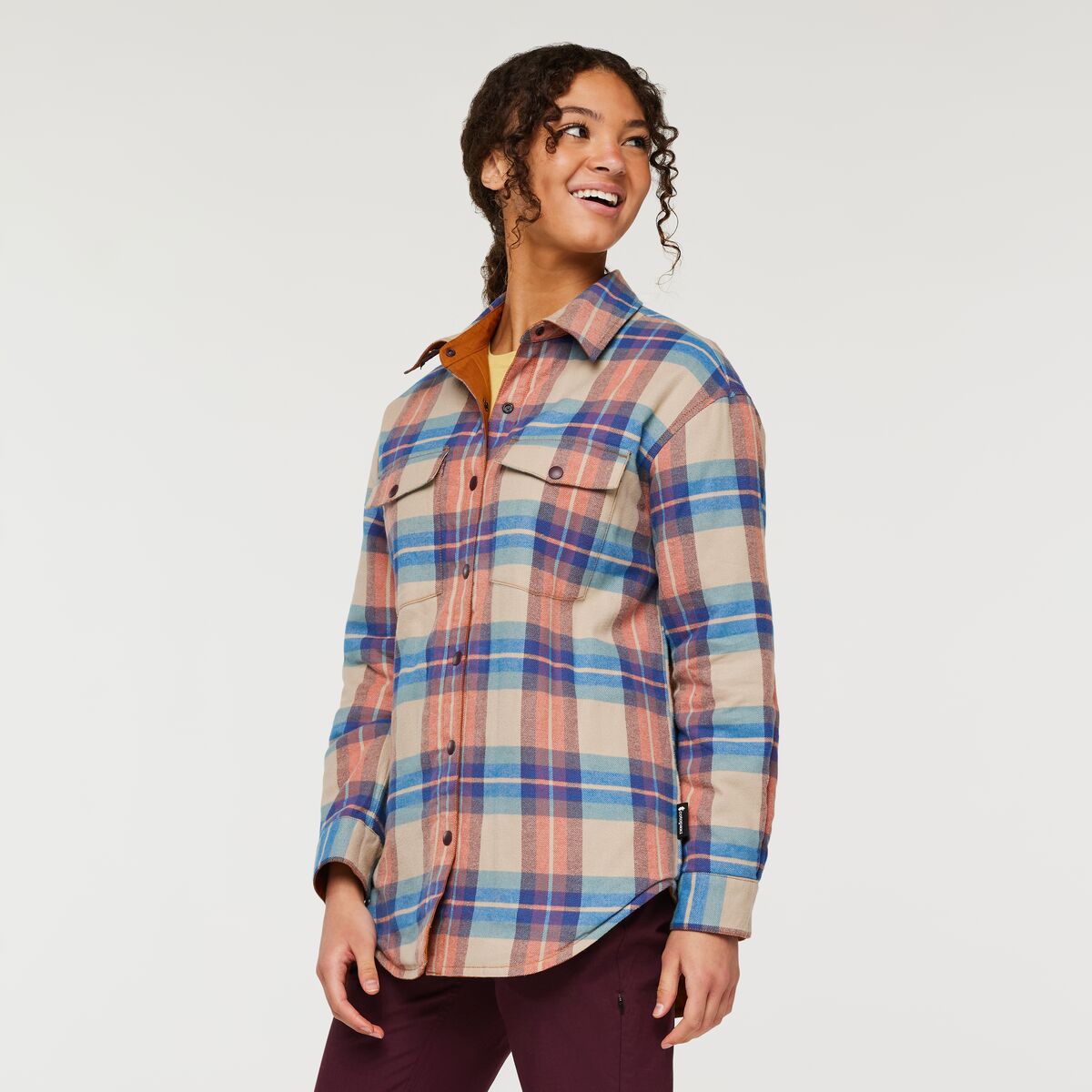 Soft peach, orange, cream, and blue plaid flannel reversible shirt by Cotopaxi. 