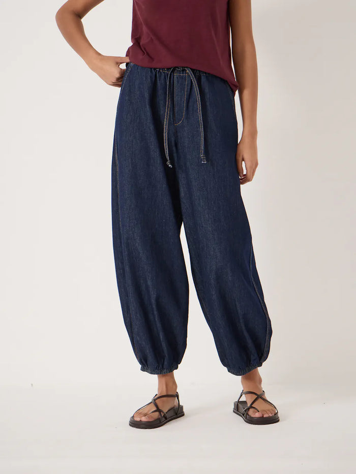Dark indigo relaxed-fit jeans with a drawstring waist and elasticated cuffs.
