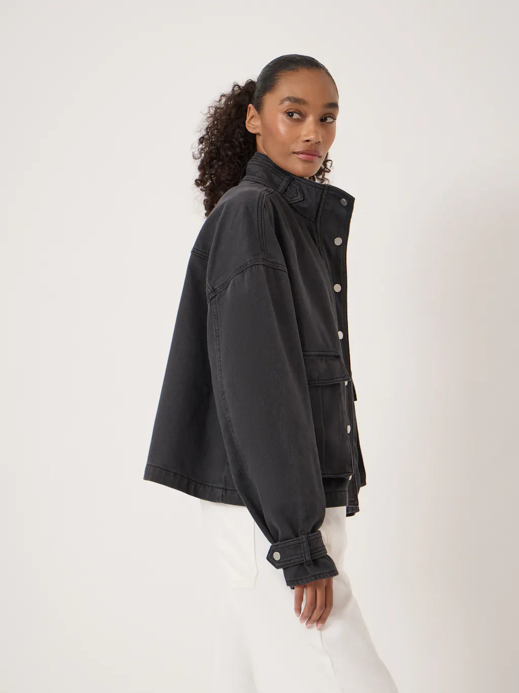 Washed black denim jacket with a relaxed fit, silver buttons and utility-style pockets.