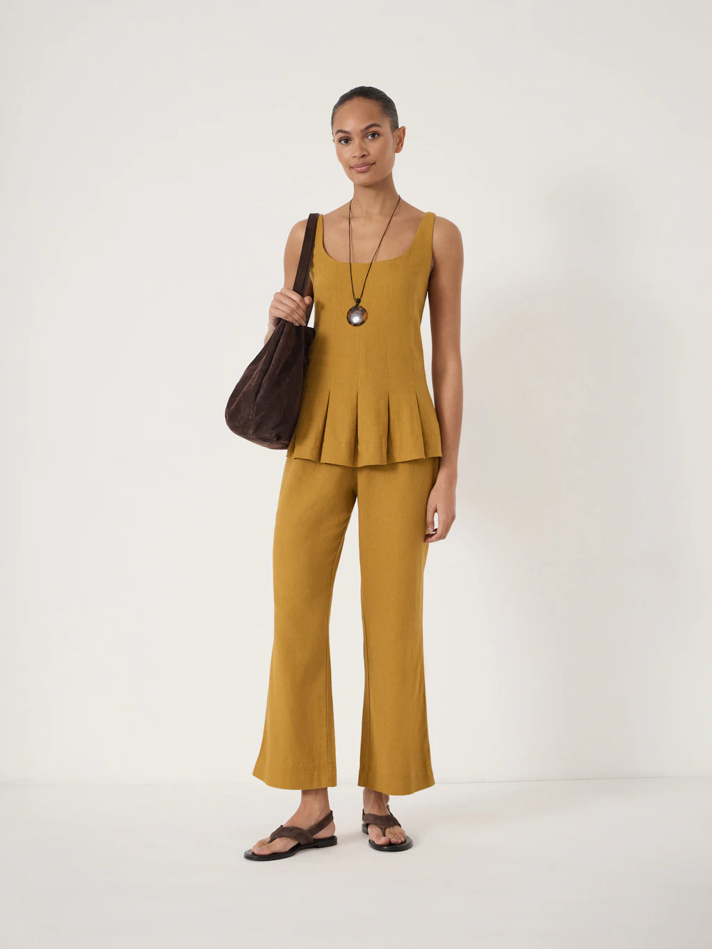 Golden yellow cropped flared linen trousers.