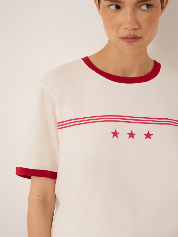 Off white t-shirt with red collar, cuffs, and stars and stripes graphic.