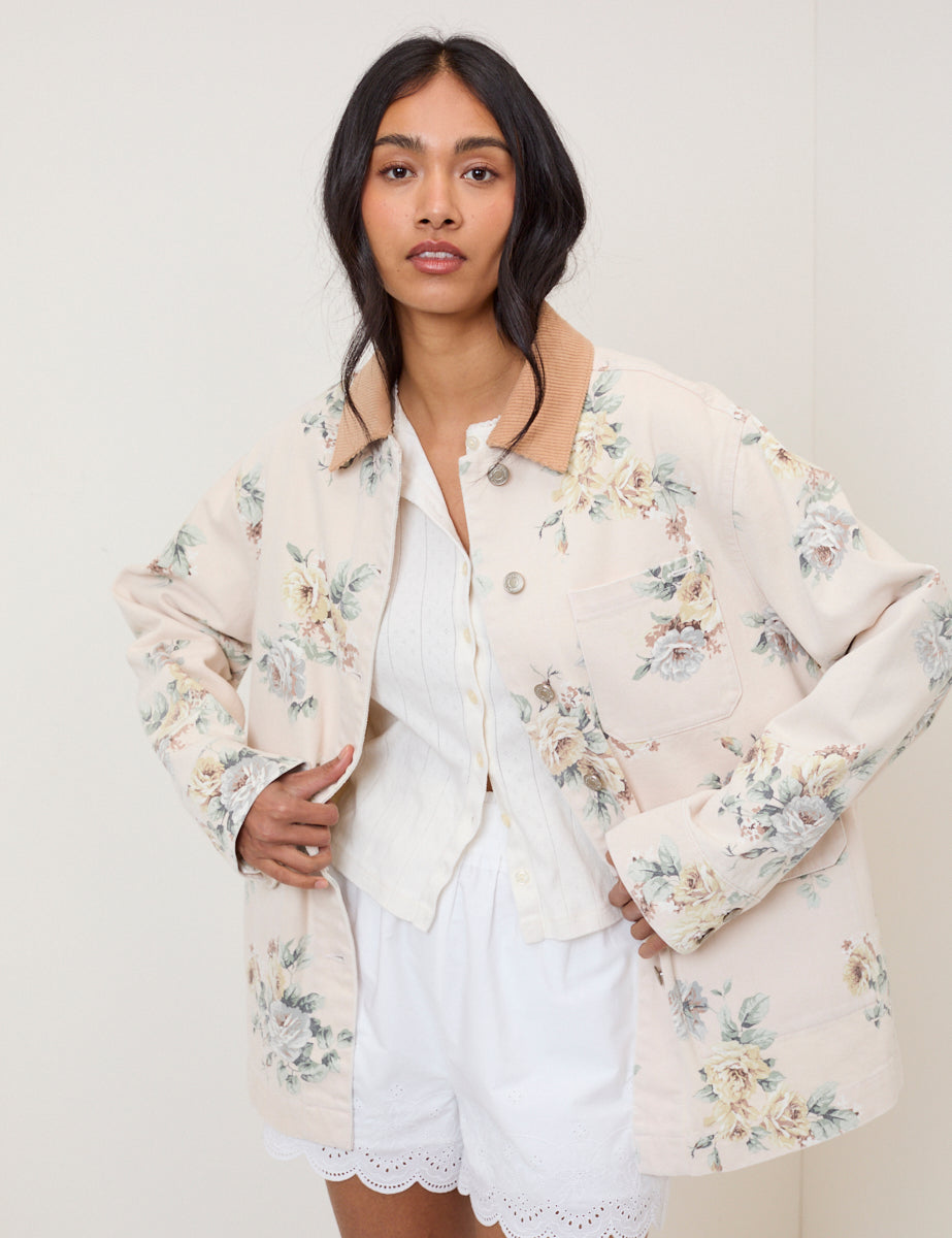Blush pink denim jacket with rose pattern and soft cord collar.