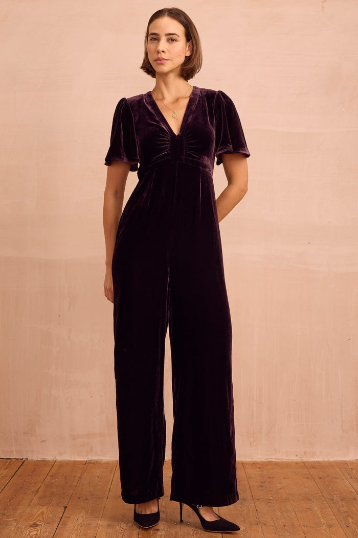 Deep plum velvet midi dress with V-neckline, short flutter sleeves, and fitted waist.