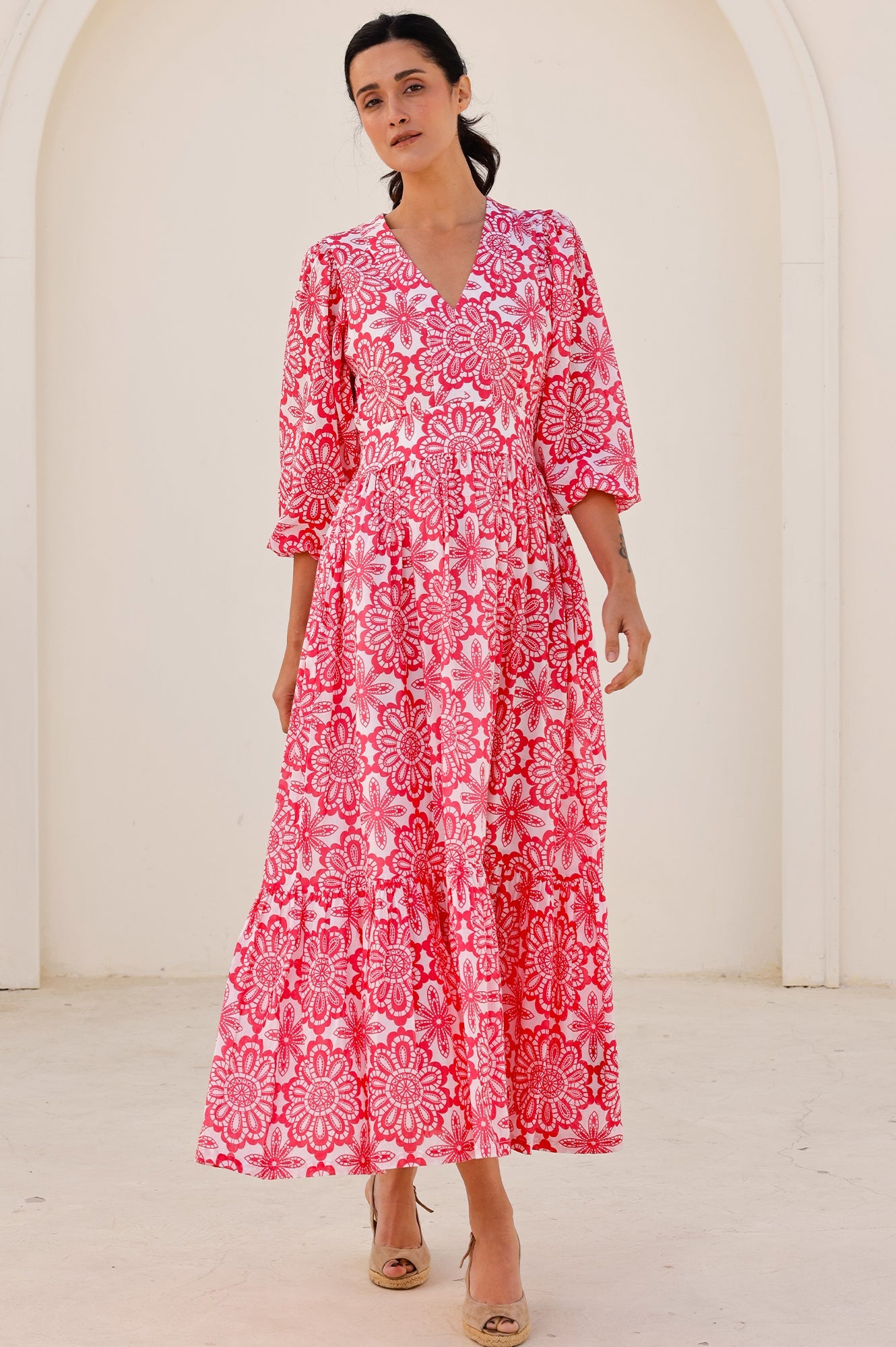 Pink and white floral maxi dress with V-neckline, three-quarter sleeves, fitted waist, and tiered skirt.
