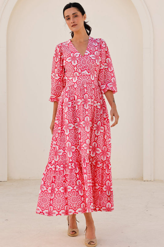 Pink and white floral maxi dress with V-neckline, three-quarter sleeves, fitted waist, and tiered skirt.