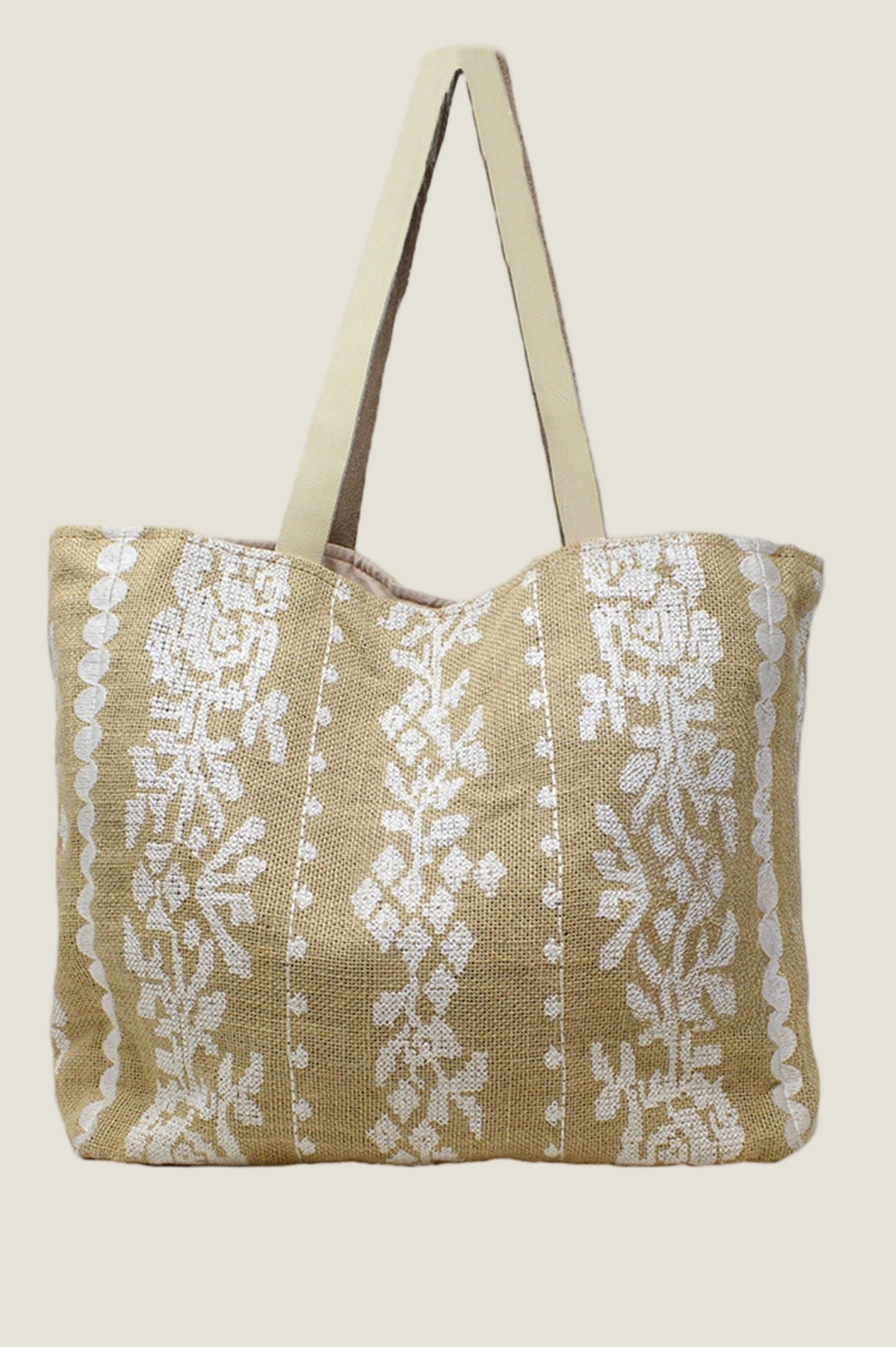 Natural jute and white tote bag with floral stripe pattern and long shoulder straps.