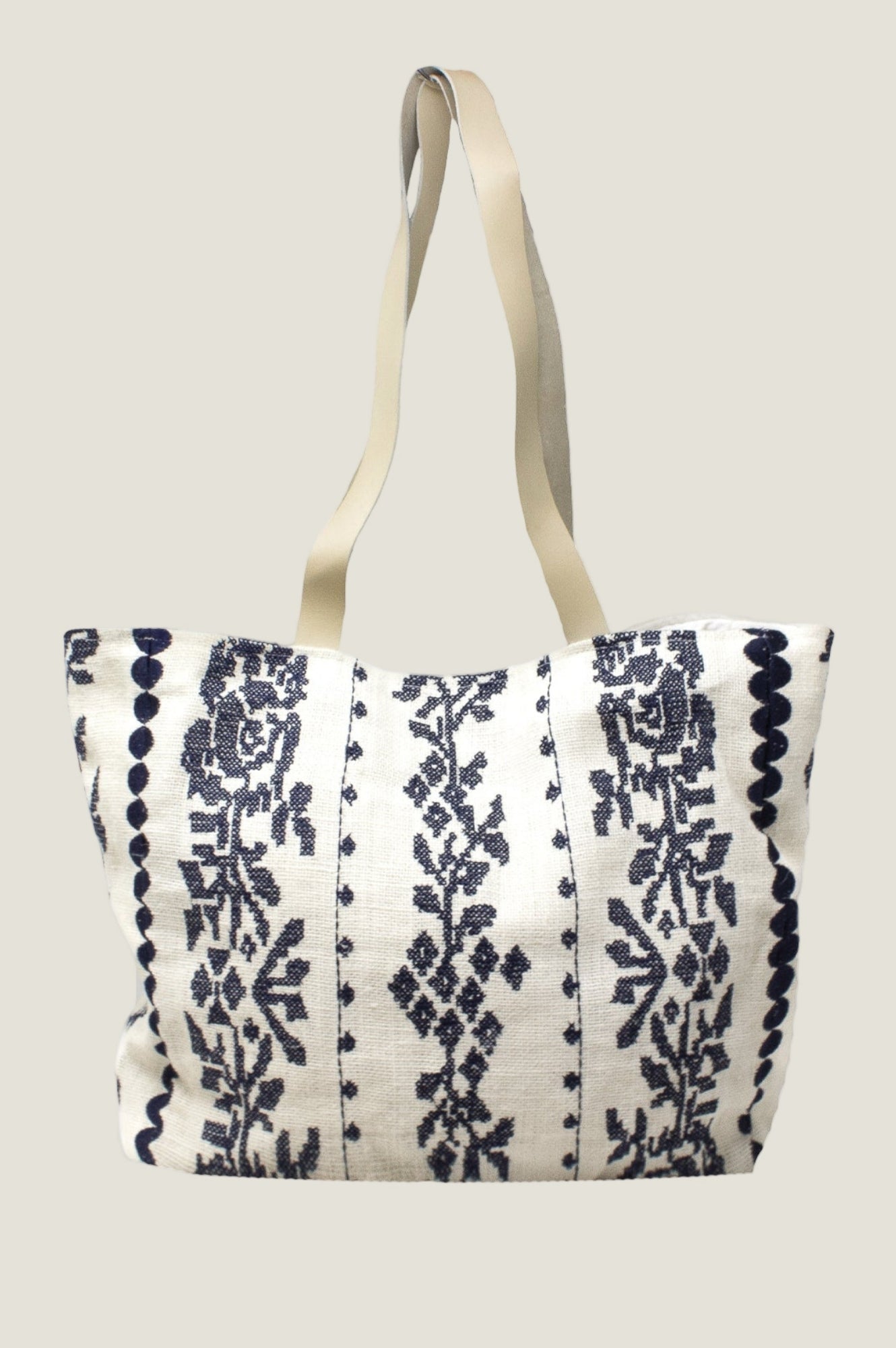 White and navy jute tote bag with floral stripe pattern and long shoulder straps.
