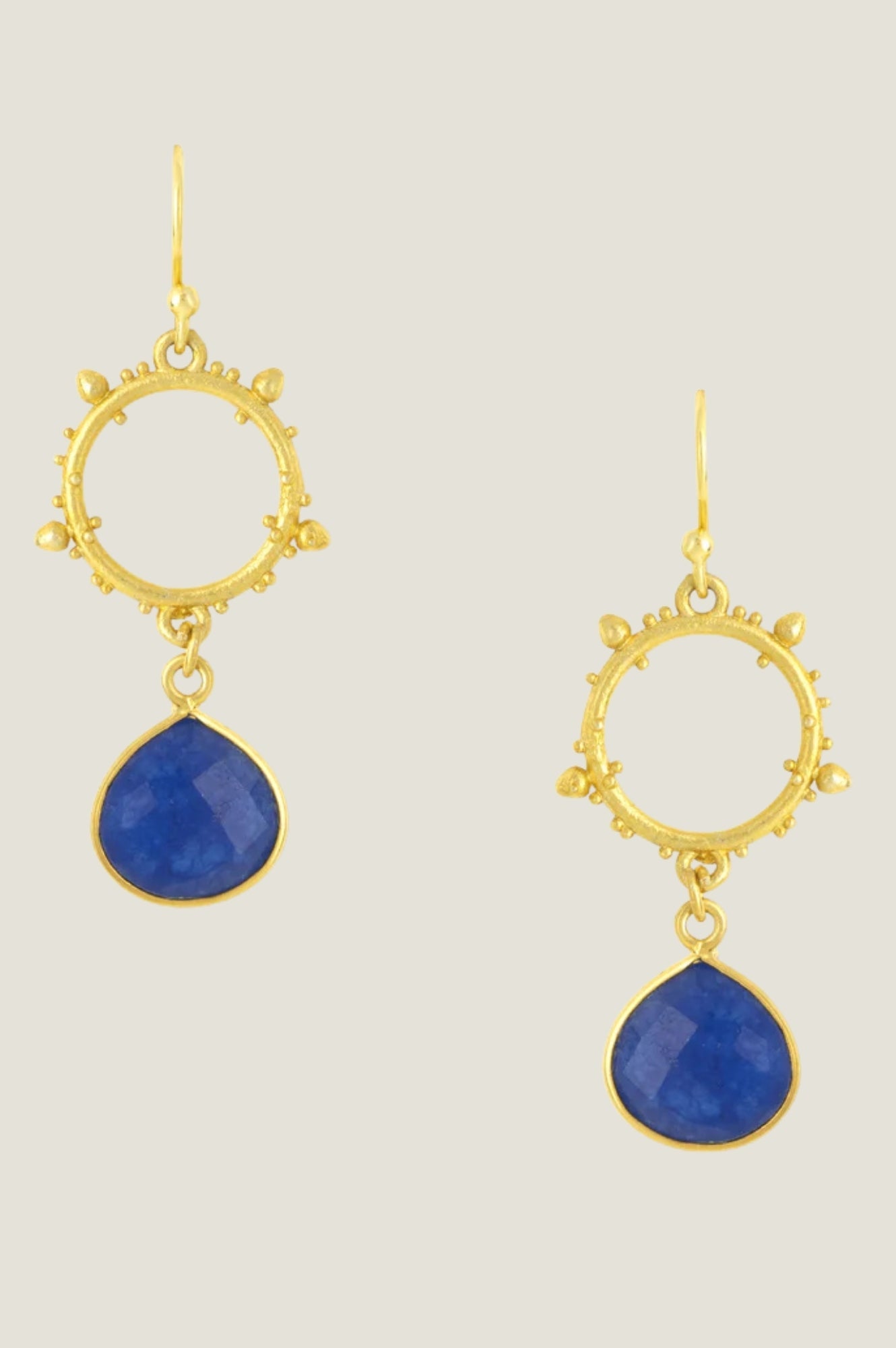 Gold drop earrings with circular textured hoop and deep blue jade pendant.