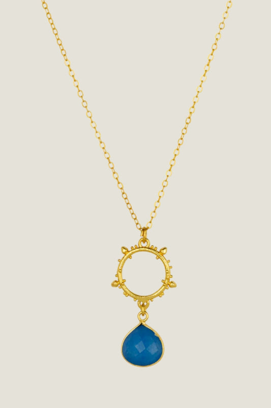Gold pendant necklace with decorative circular charm and faceted deep blue drop jade gemstone.