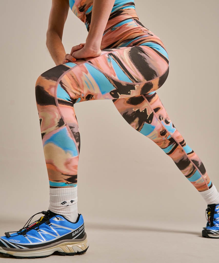 Coral, peach, brown, and turquoise abstract print activewear leggings.