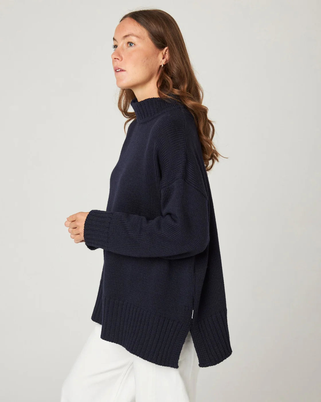 Model wearing deep navy merino wool knitted jumper by Peregrine Clothing, filtered for the Deep Winter and Cool Winter colour seasons.