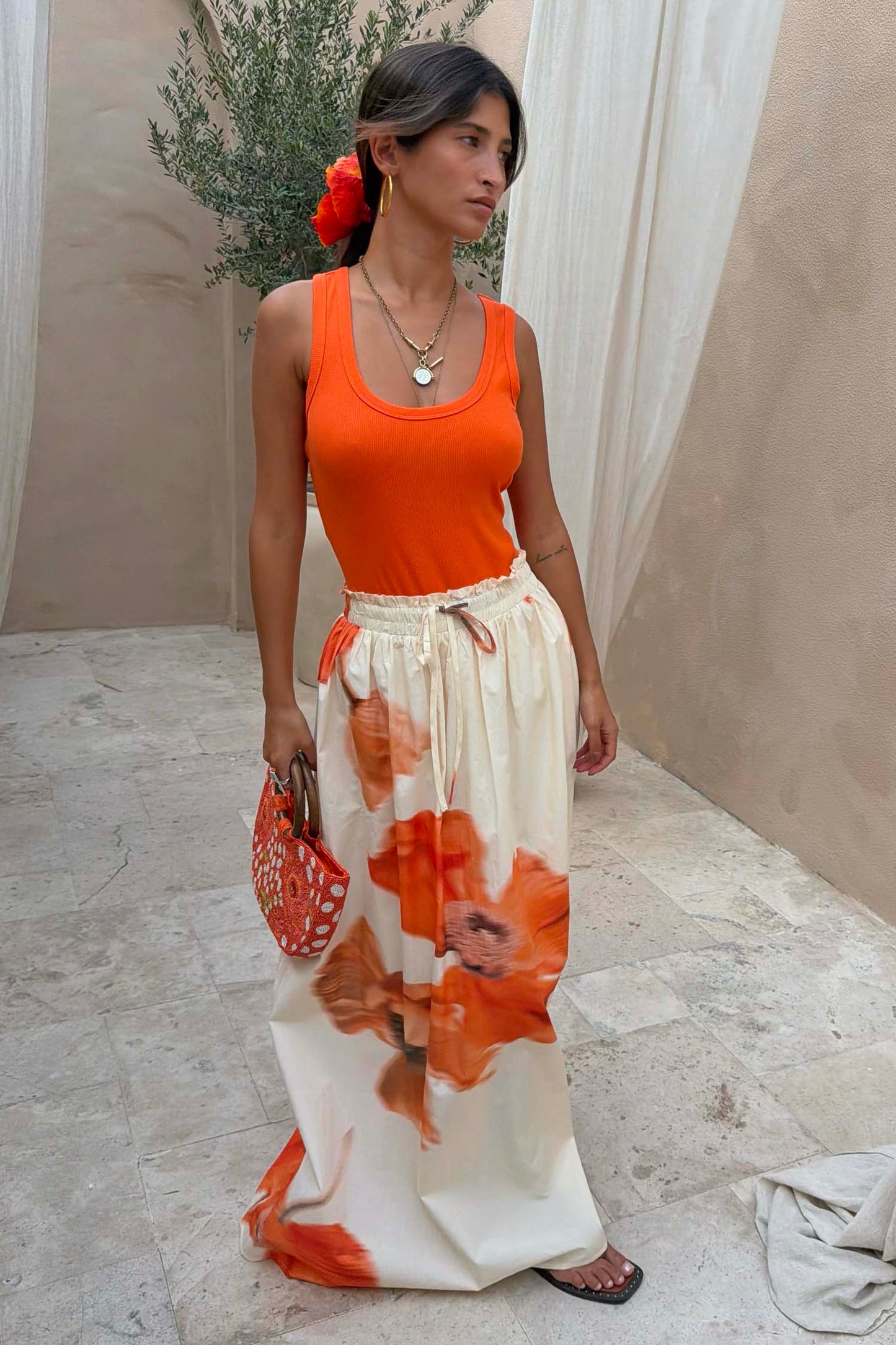Cream maxi skirt with an elasticated waistband and large orange floral print.