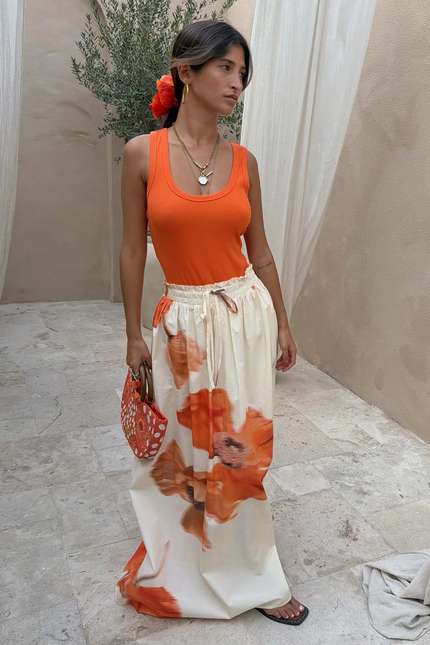 Cream maxi skirt with an elasticated waistband and large orange floral print.