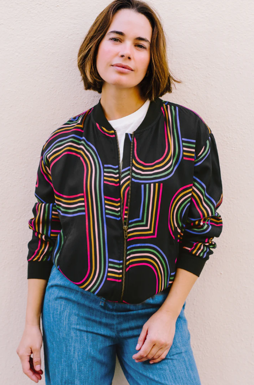 Black zip-front jacket with colourful geometric line pattern in pink, blue, green, and yellow