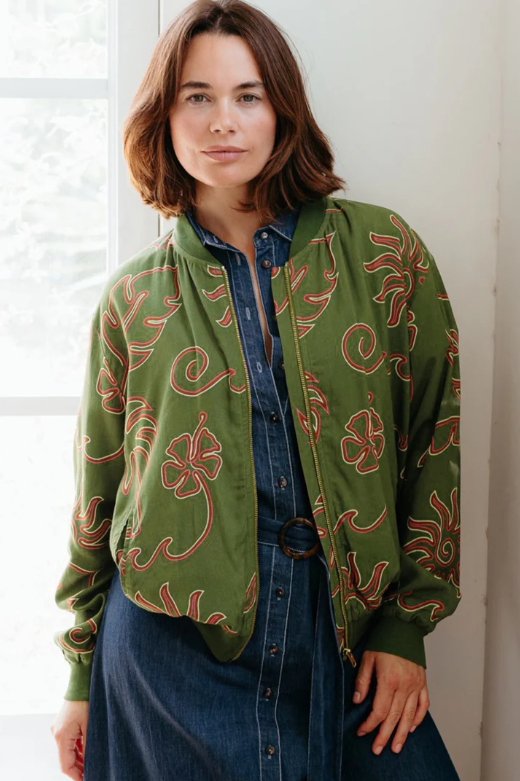 Olive green jacket with coral-red abstract pattern, zip front, and relaxed fit