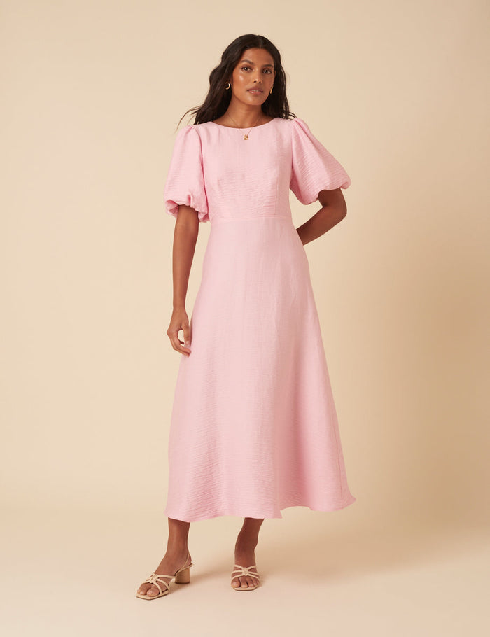 Baby pink round neck midi dress with puff sleeves and bow tie back.