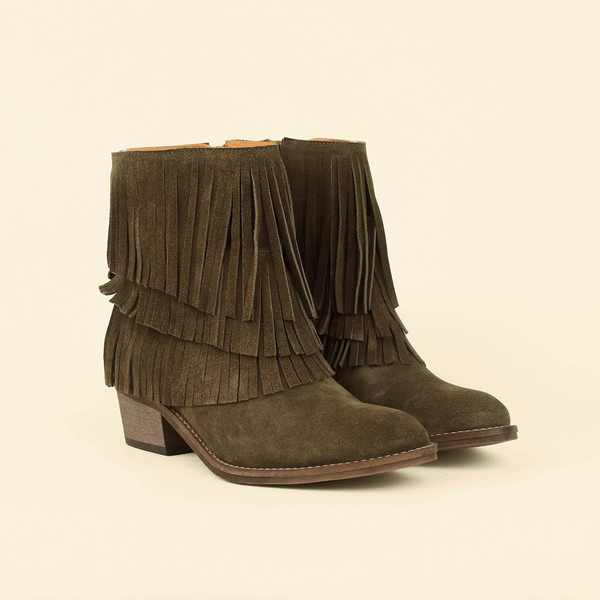 A pair of olive green suede fringe ankle boots with low block heels, shown on a plain cream background.