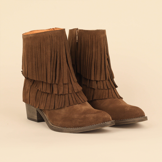 A pair of brown suede fringe ankle boots with low block heels, shown on a plain beige background.