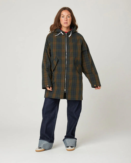 Model wears a waxed cotton cagoule in deep navy and khaki brown check, by Peregrine Clothing and filtered for the Deep Autumn or Warm Autumn colour seasons by Shop My Palette.