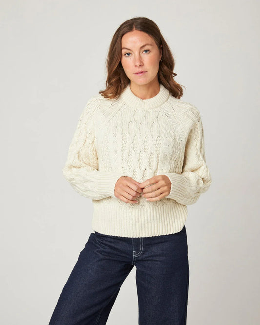 Model wears a cream ecru merino wool knitted sweater by Peregrine Clothing, filtered for the Light Spring, Clear Spring, and Warm Spring colour seasons.