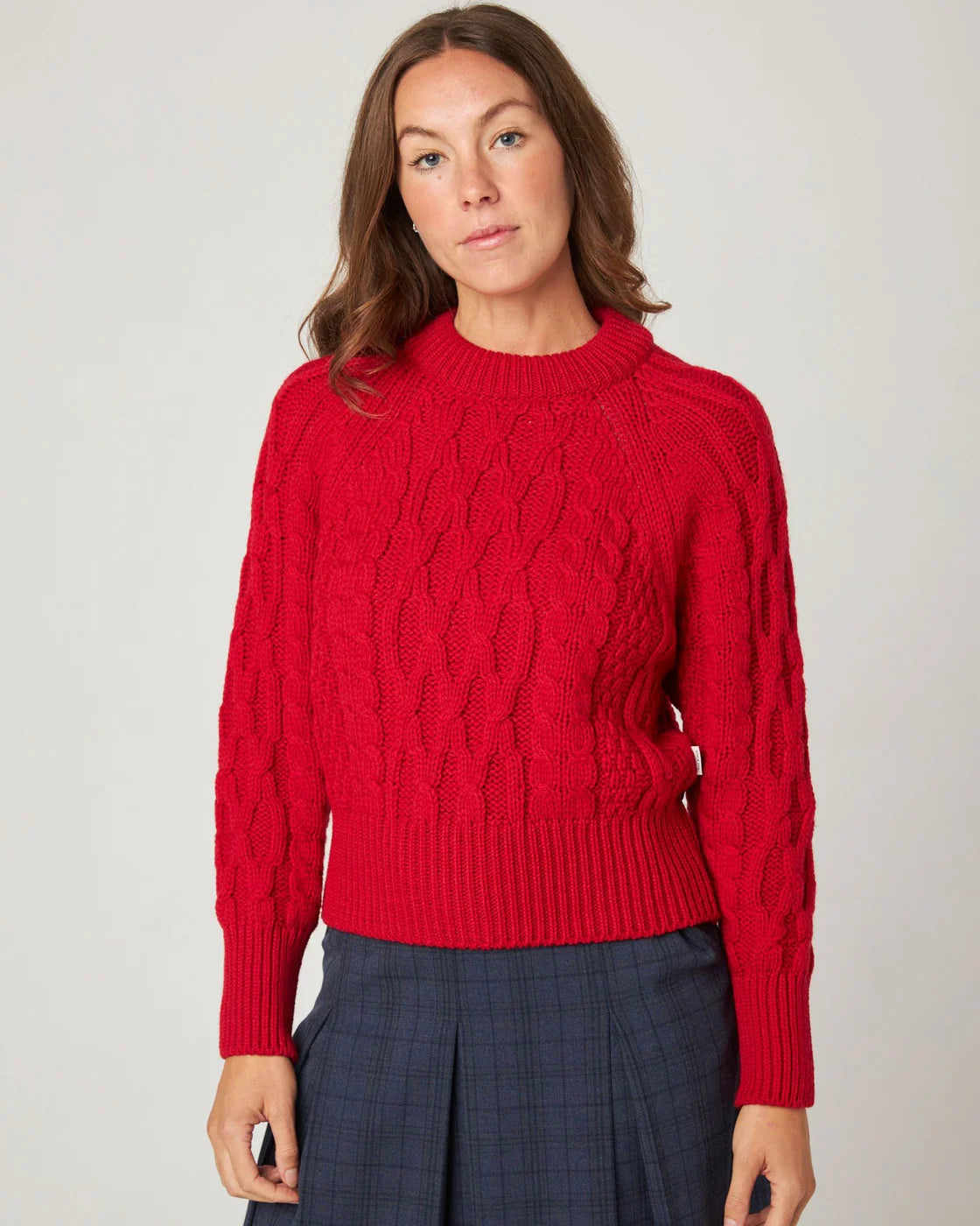Model wears red merino knitted sweater by Peregrine Clothing, filtered for the Clear Spring, Warm Spring, and Clear Winter colour seasons.