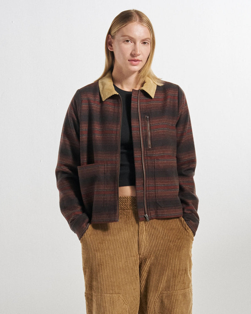 Model wears a dark rust striped overshirt, black t-shirt and camel cords.