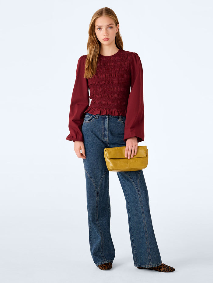 Shirred burgundy cotton blouse with balloon sleeves.