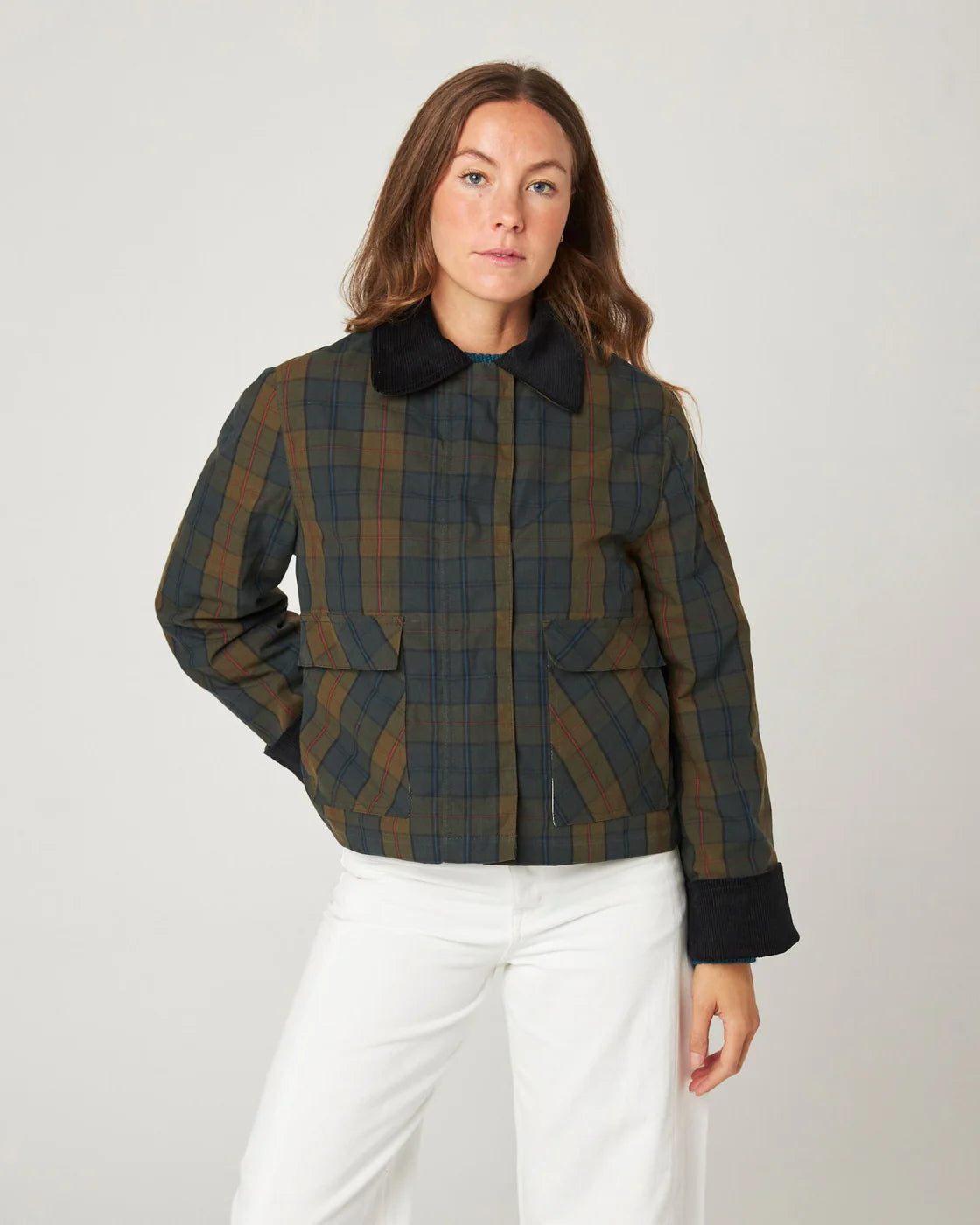 Model wears a tartan check waxed cotton jacket in knaki brown and navy. Made by Peregrine Clothing and filtered for the Deep Autumn and Warm Autumn seasons by Shop My Palette.