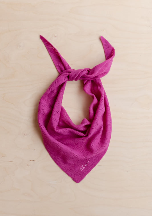 Bright fuchsia merino wool neck scarf with soft knit texture and triangular shape