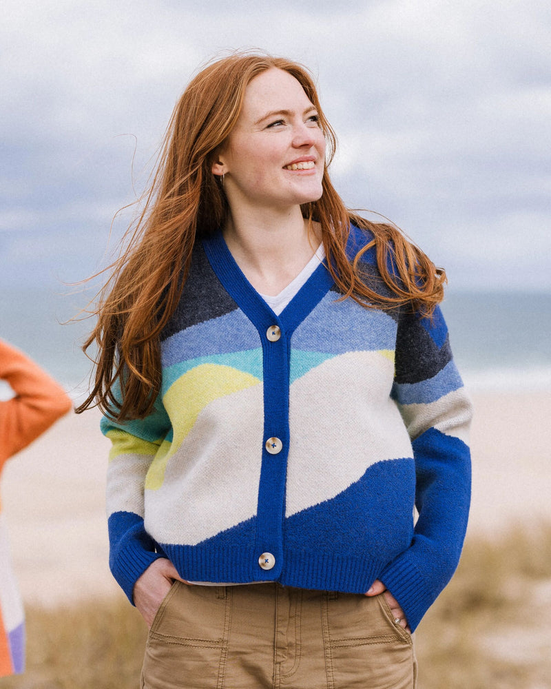 Woman wears cobalt blue abstract pattern cardigan.