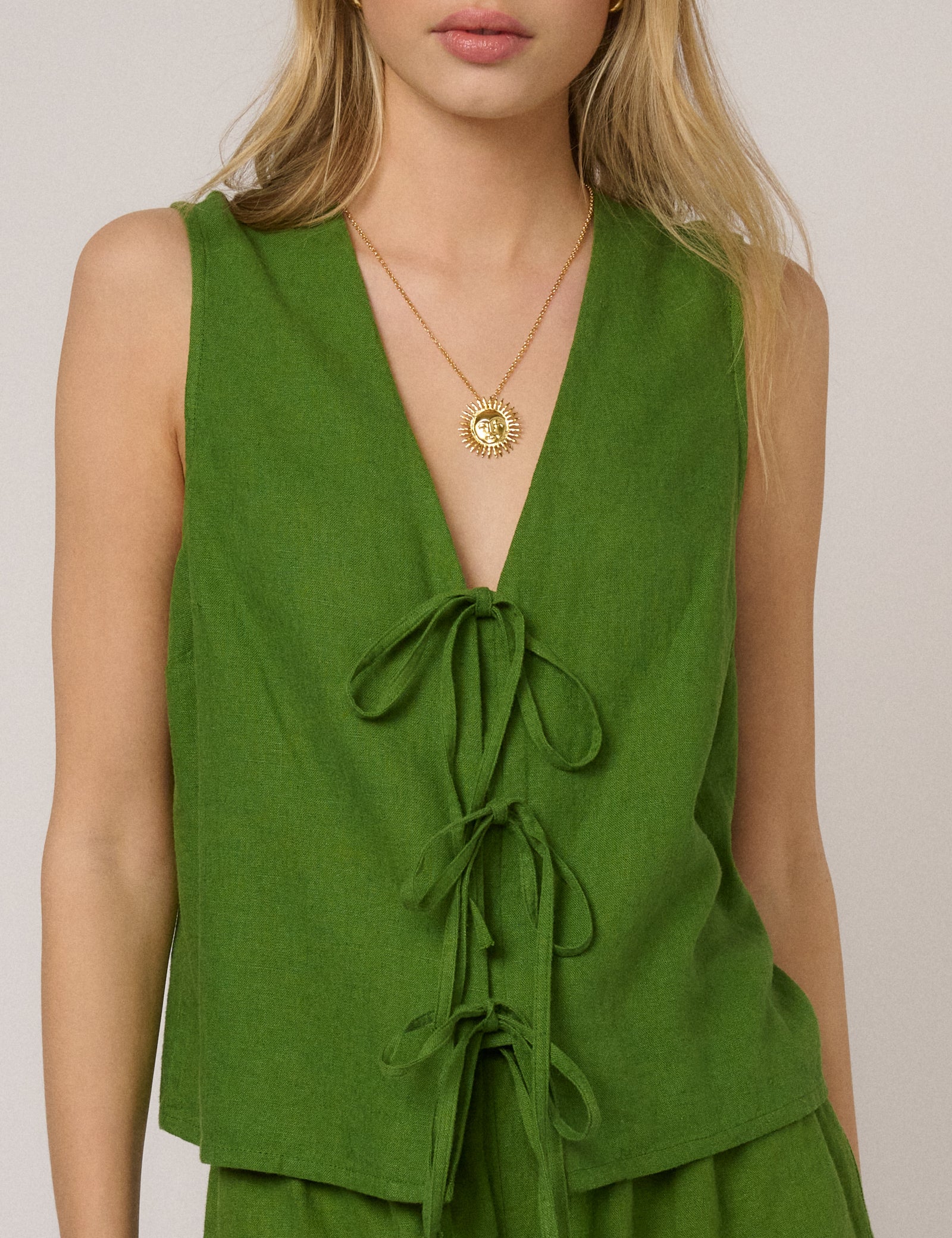 Green linen-blend tie-front sleeveless top.