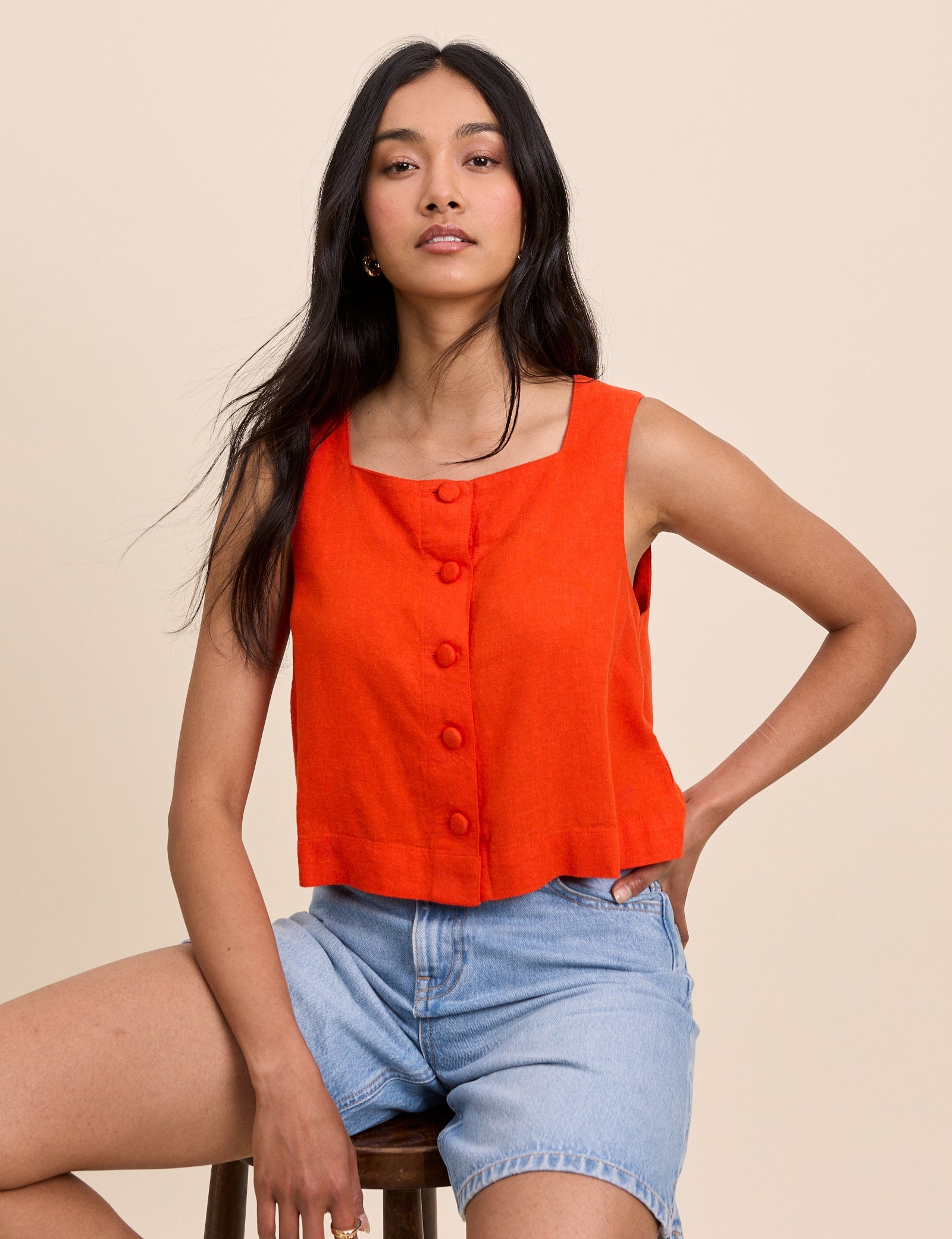 Orange button front sleeveless top.