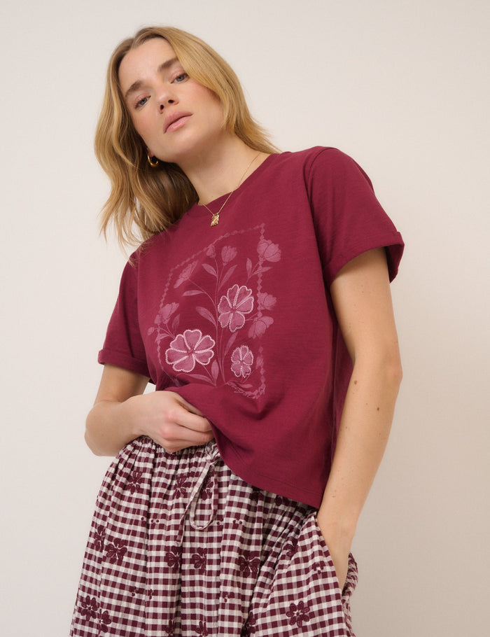 Burgundy t-shirt with flower design.