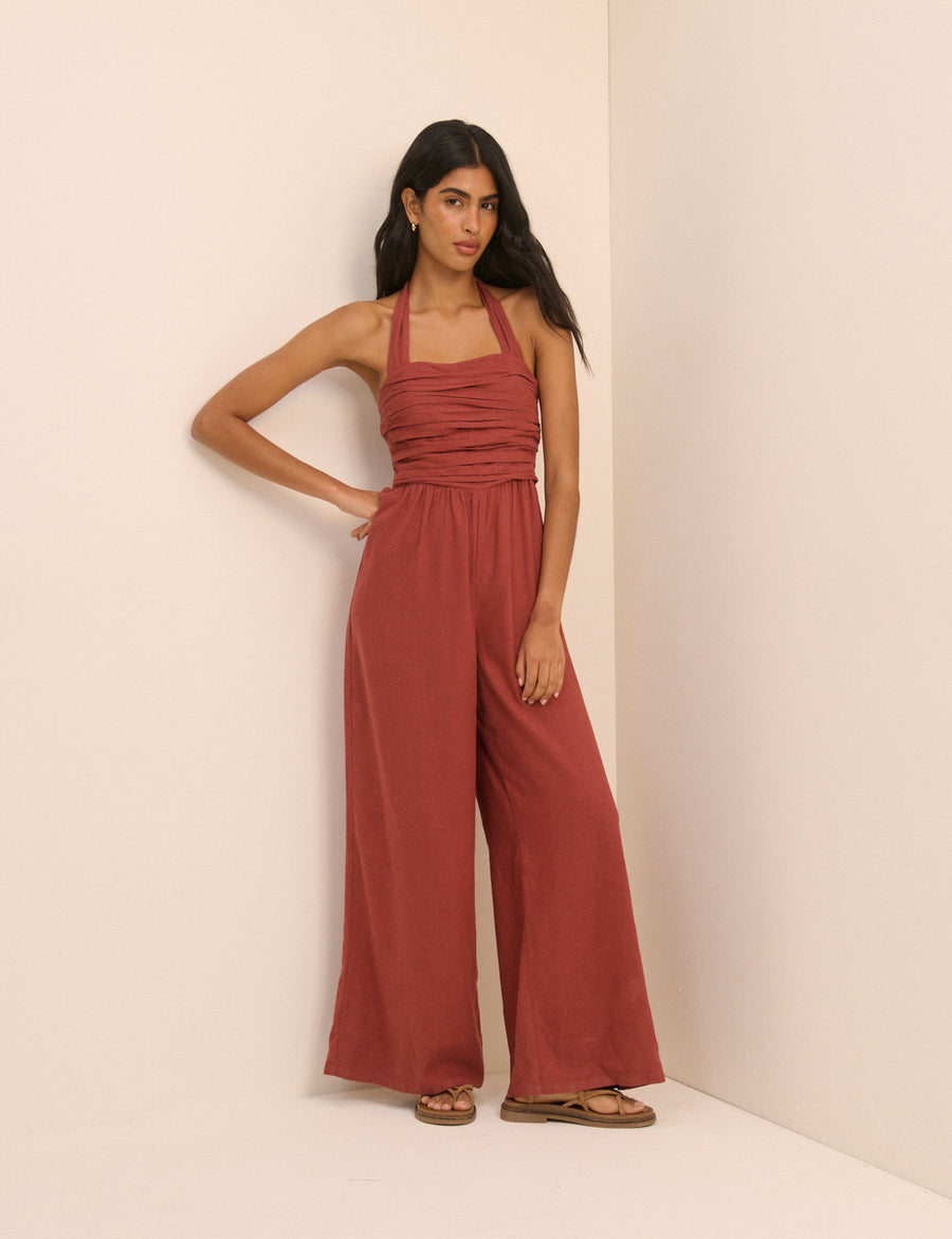 Rust red ruched halterneck jumpsuit.