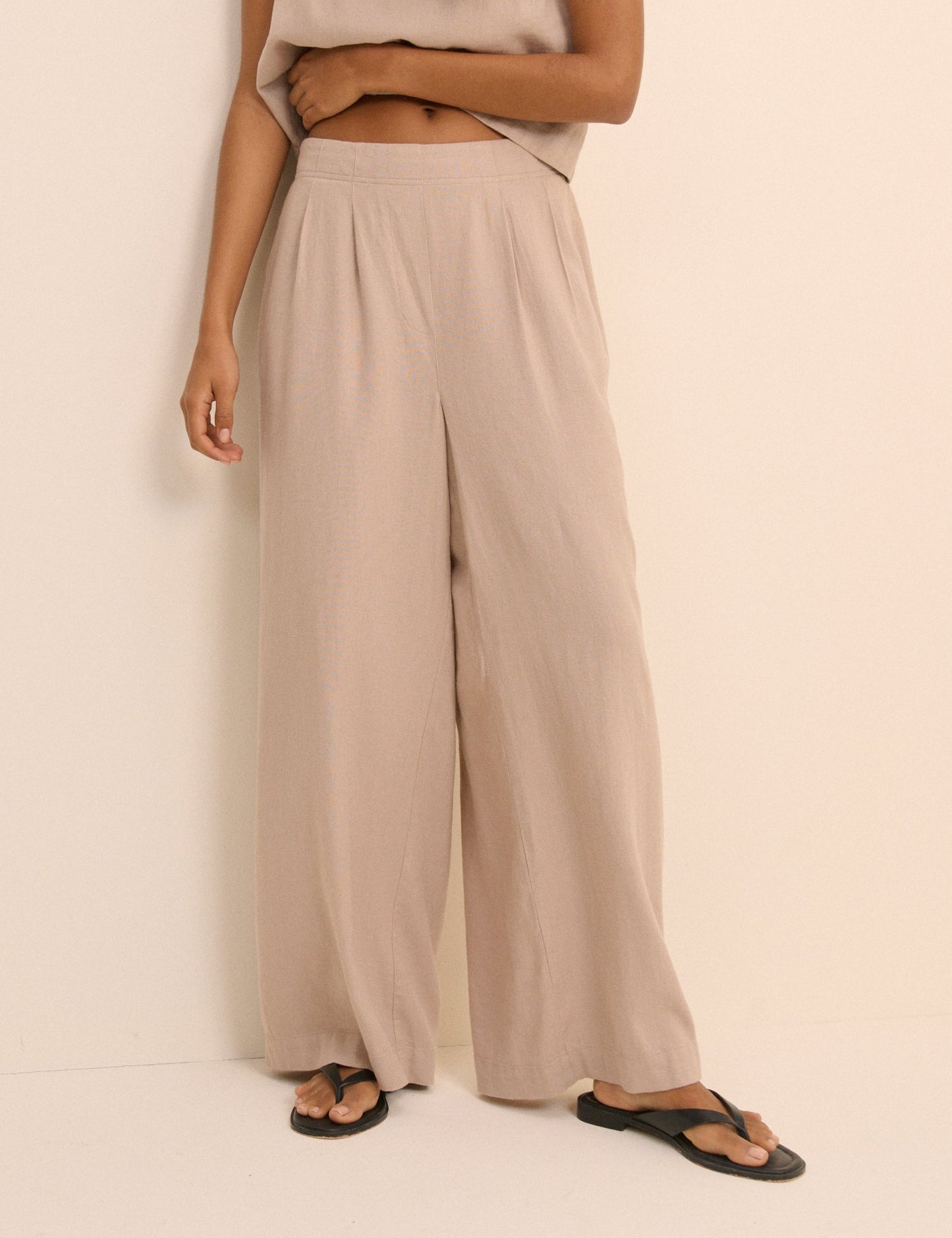 Sand-beige wide leg linen blend trousers.