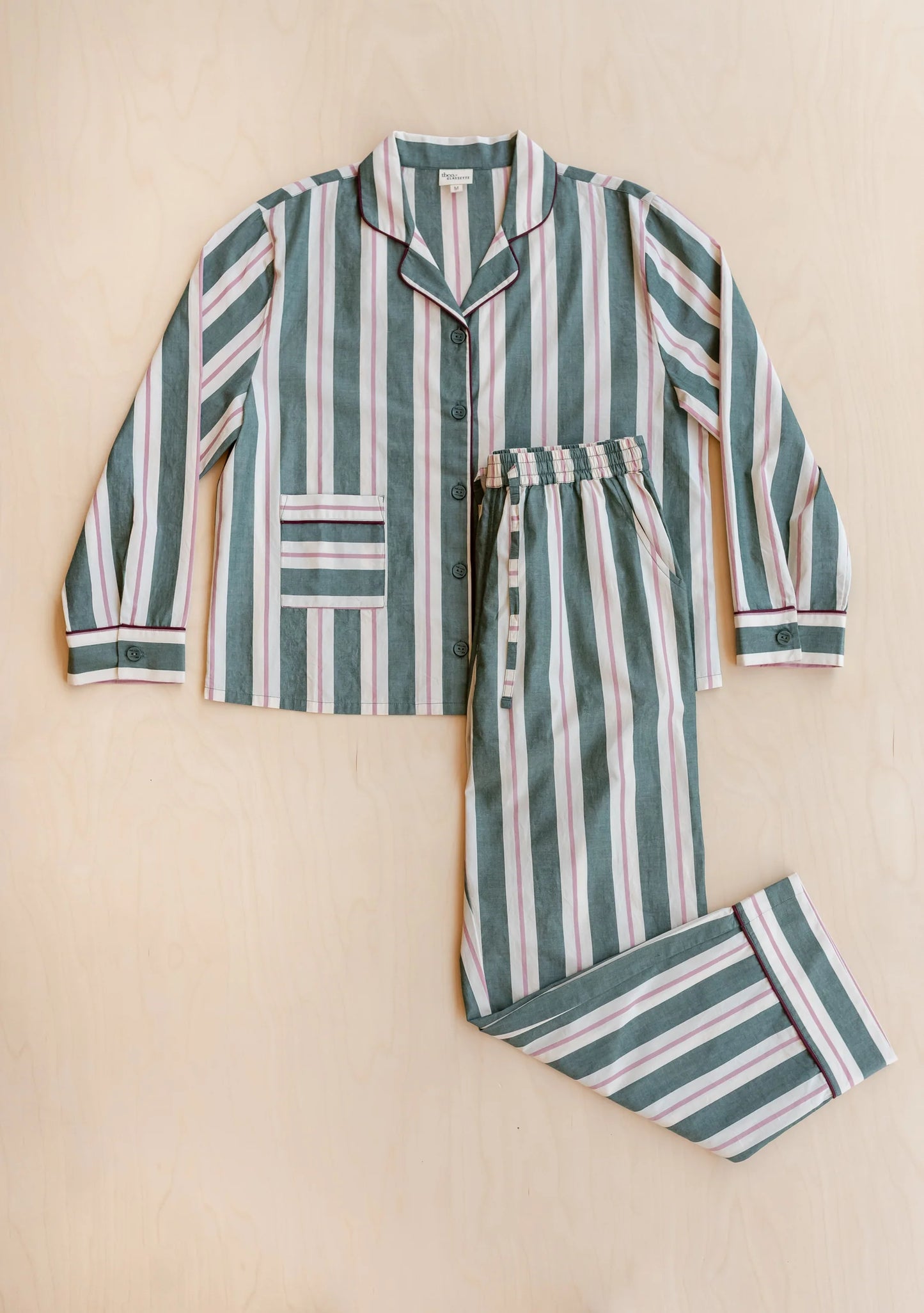 Green and pink striped cotton pyjama set on a beige background. Pyjamas are by TBCo x Glassette and are filtered by Shop My Palette for the Cool Summer and Light Summer colour seasons.