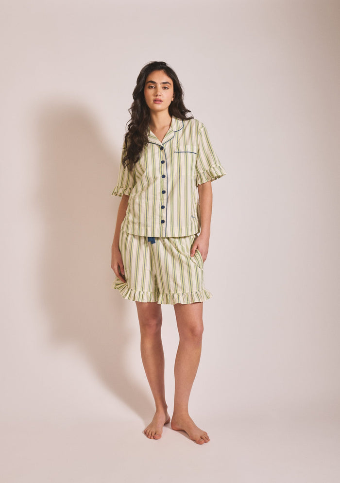 Sage green and white striped short-sleeve pyjama set with button-up shirt, ruffle trim, and matching shorts.