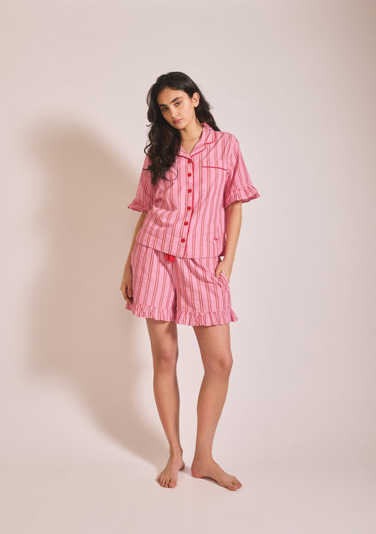 Pink and red striped short-sleeve pyjama set with button-up shirt, ruffle trim, and matching shorts.