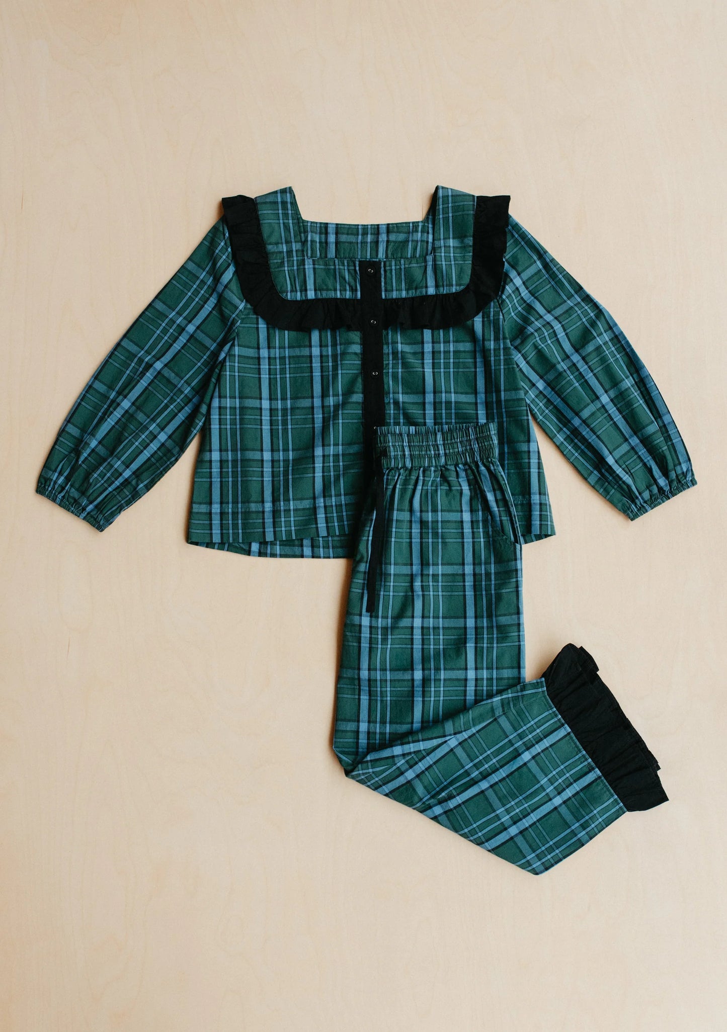 Green plaid pyjama set with black trim on a beige background. Pyjamas are by TBCo and are filtered by Shop My Palette for the Deep Winter, Cool Winter, and Clear Winter colour seasons.
