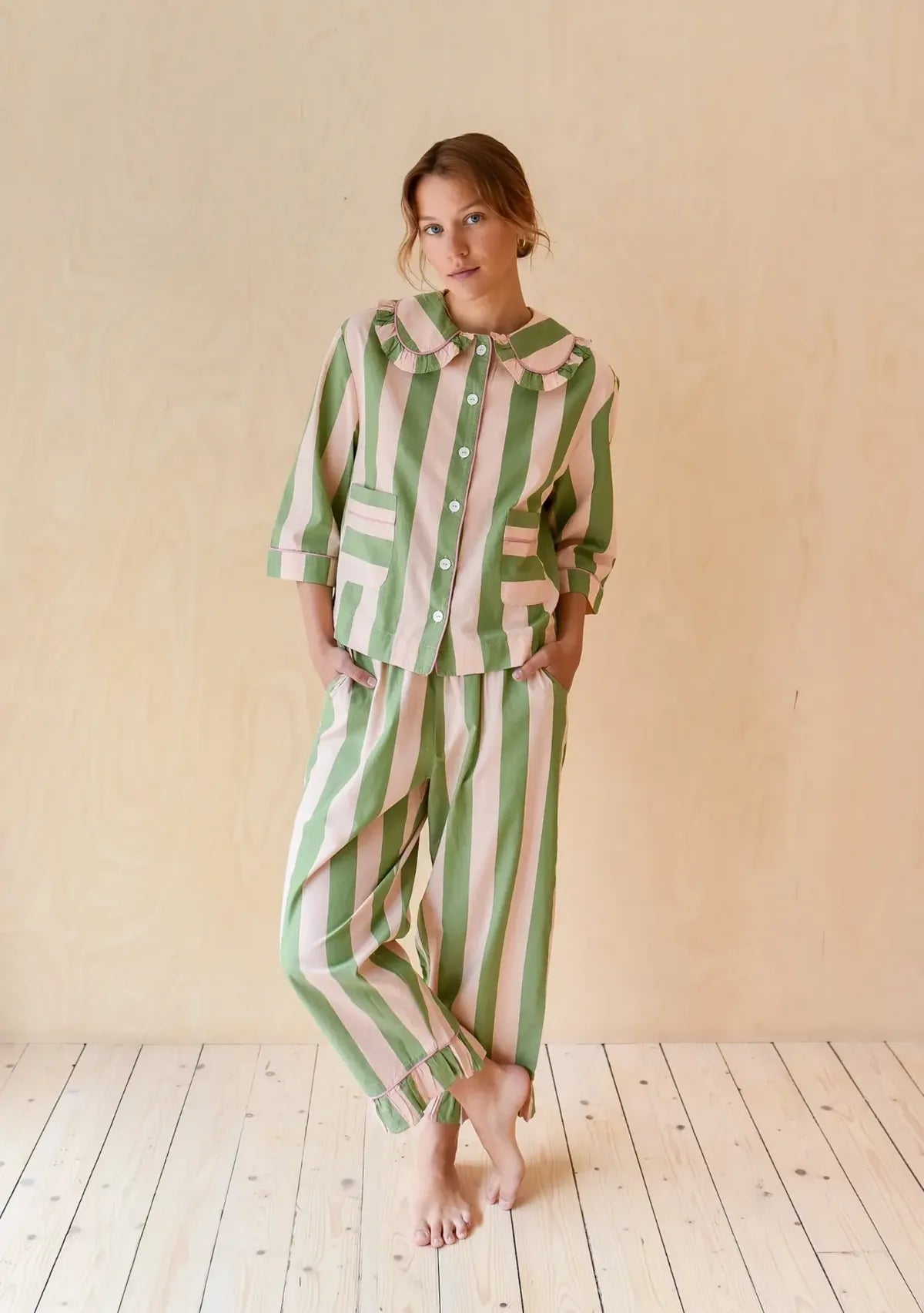 Model wearing green and cream striped cotton pyjamas by TBCo, featuring soft contrast and fresh spring greens, ideal for Light Spring and Soft Spring colour seasons, shown in a studio setting and curated by Shop My Palette.