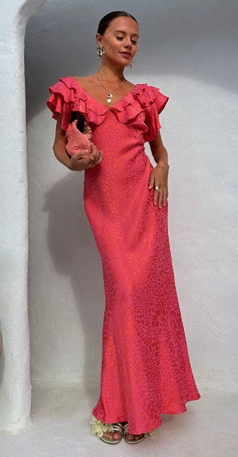 Woman wearing a pink leopard print dress with ruffled details against a white wall. The Tilda jacquard dress, by Never Fully Dressed, has been filtered for the Warm Spring, Clear Spring, and Light Spring colour seasons by Shop My Palette.