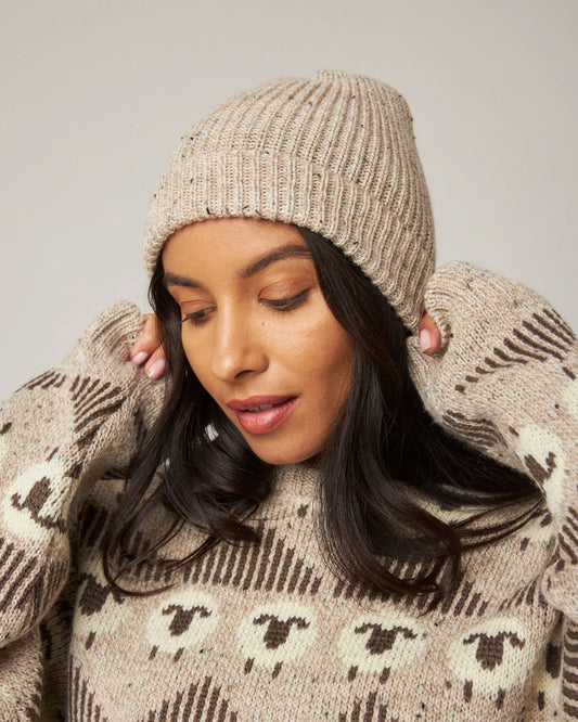 Model is wearing an oatmeal coloured ribbed merino wool knit beanie by Peregrine Clothing, filtered for the Soft Autumn, Warm Autumn, and Deep Autumn colour seasons by Shop My Palette.